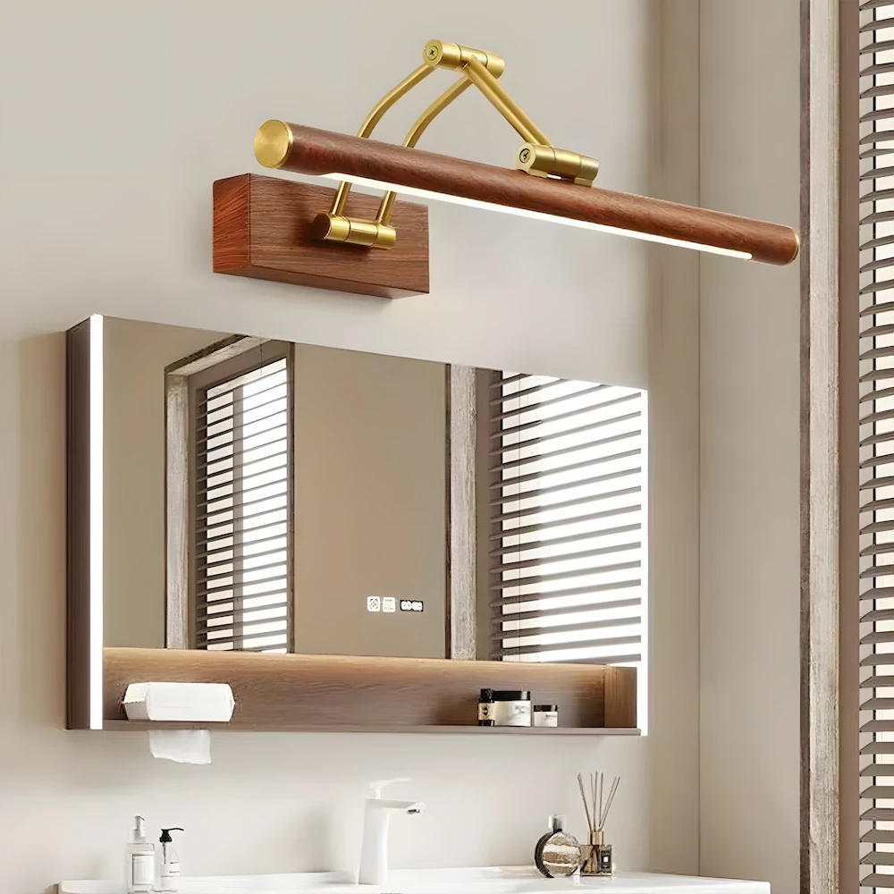 Brass and wood picture light providing elegant vanity lighting above marble bathroom mirror with natural wood cabinetry