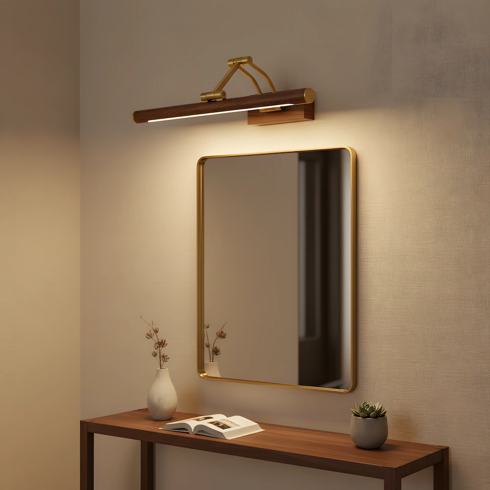 Wood grain picture light above brass-framed mirror in modern entryway with walnut console table and minimalist styling